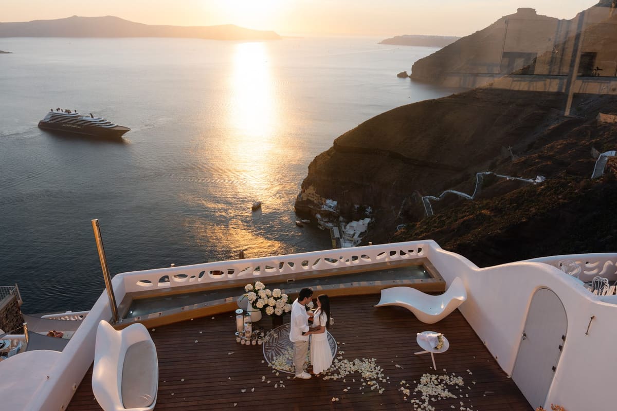 Surprise proposal on a private terrace in Fira at sunset, caldera and cruise ship below