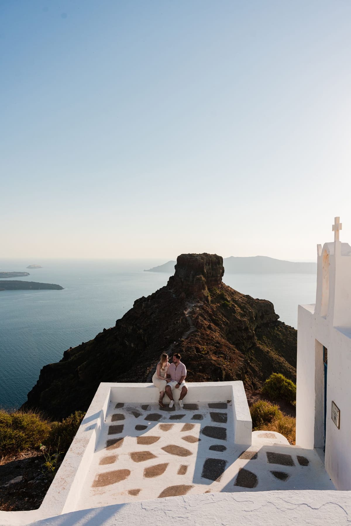 Couple kissing on the chapel terrace below Skaros Rock, Imerovigli, Santorini