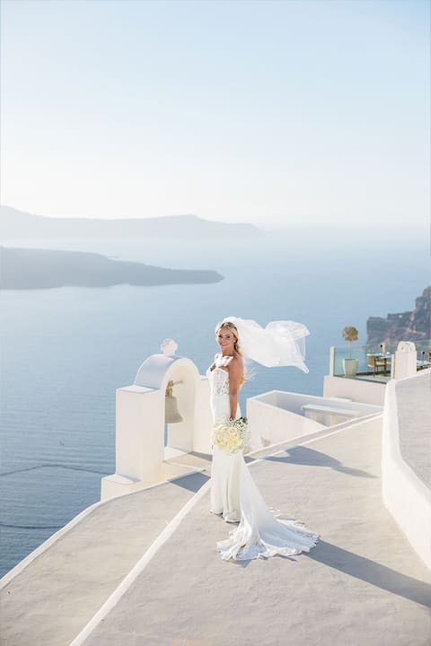 Bride's veil flying over the white domes of Fira with the caldera below, Santorini